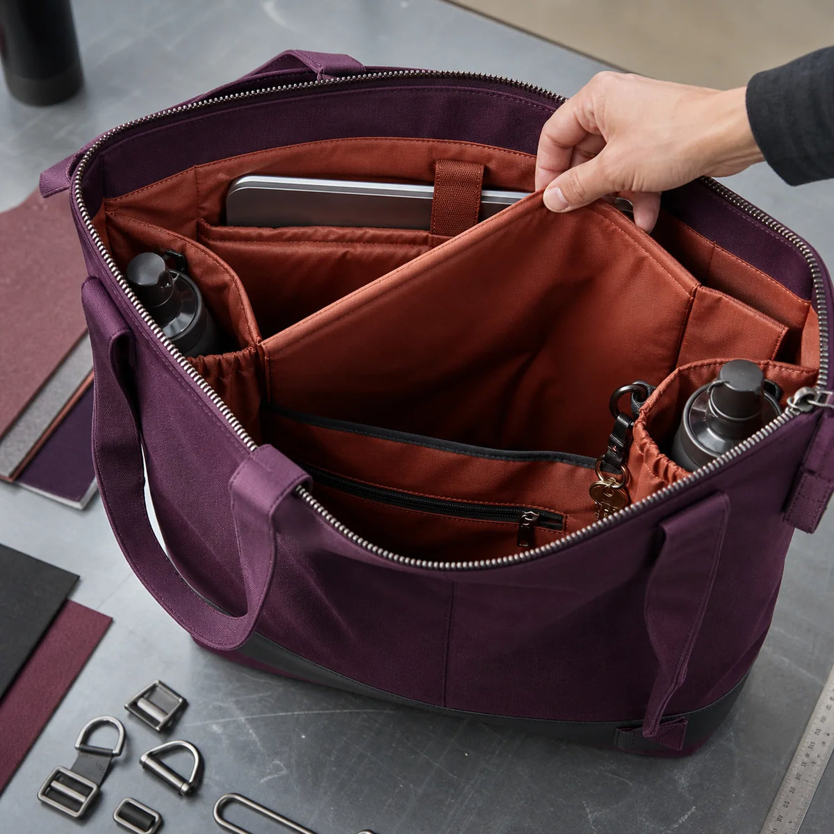 Open plum canvas tote with zipper padded sleeve bottle pockets and internal divider