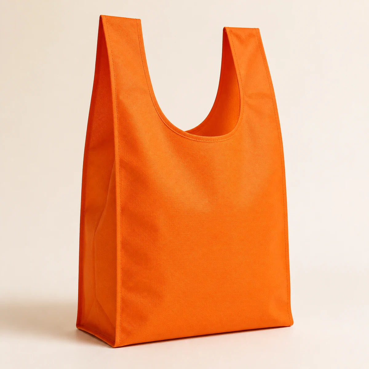 Portacompras reutilizable estilo camiseta naranja con asas integradas