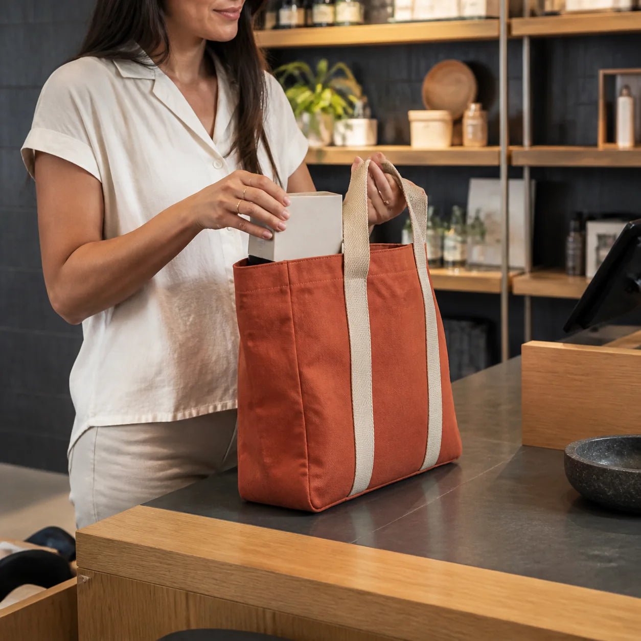 Structured 14oz terracotta canvas tote used at a retail checkout