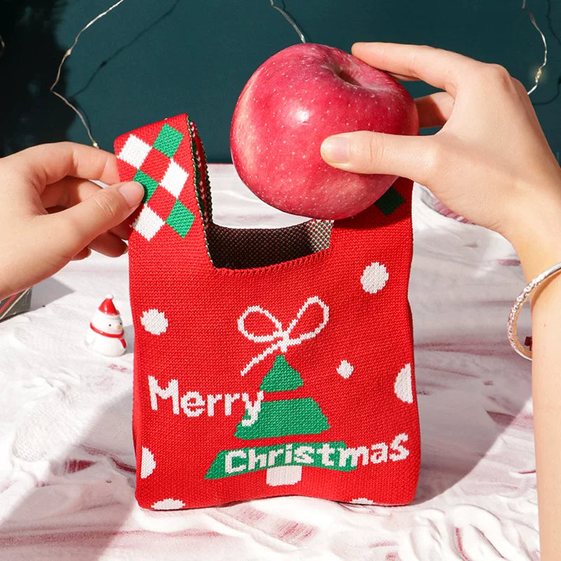 A red Christmas Tree carry bag being packed with an apple for a remote employee presentation-route test