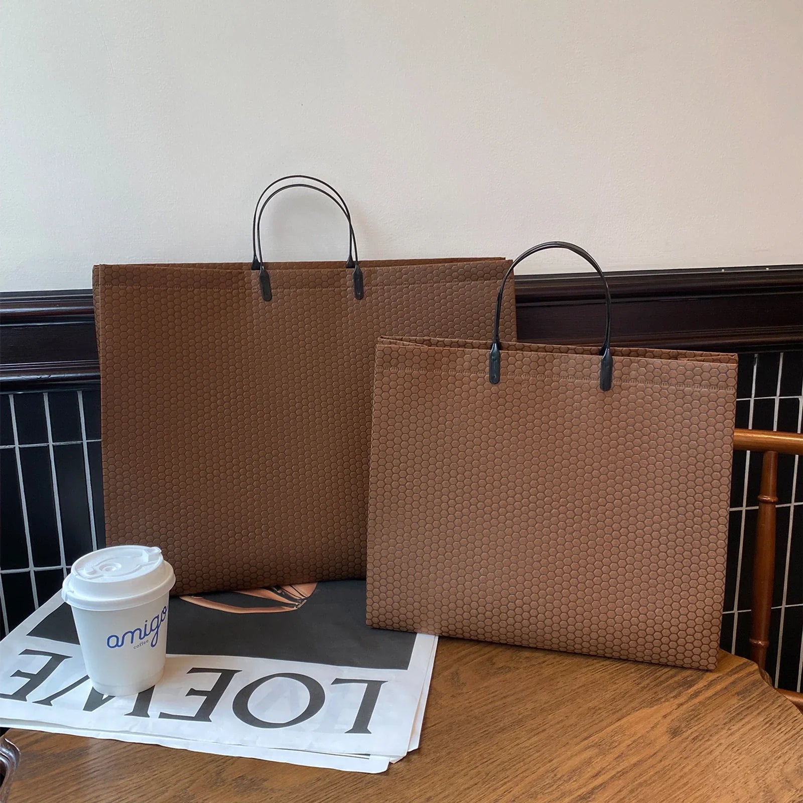 Coffee-brown non-woven tote bag with flat matching handles and a honeycomb-patterned body