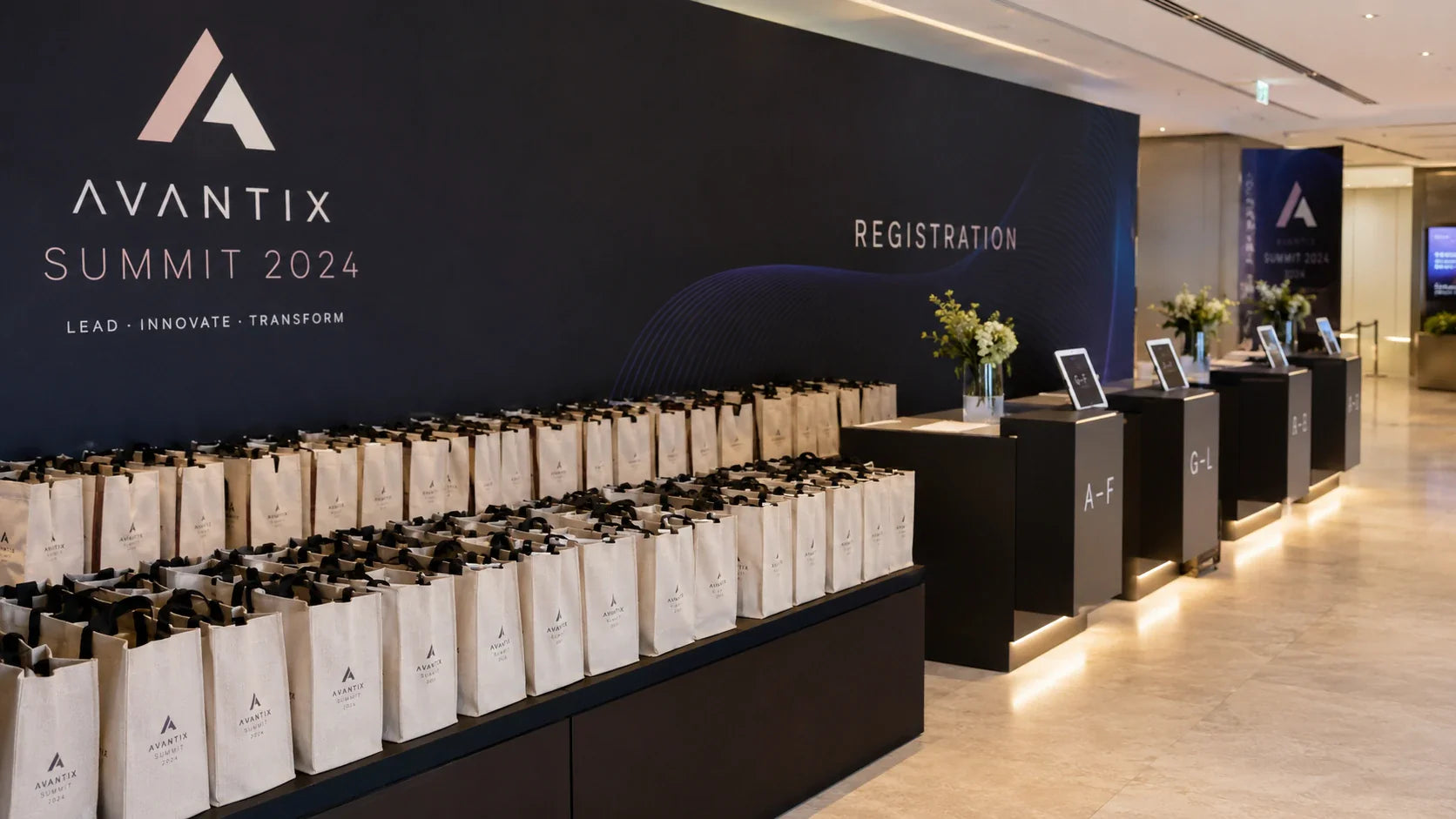 Neatly aligned custom printed recycled tote bags at a modern corporate event registration desk.