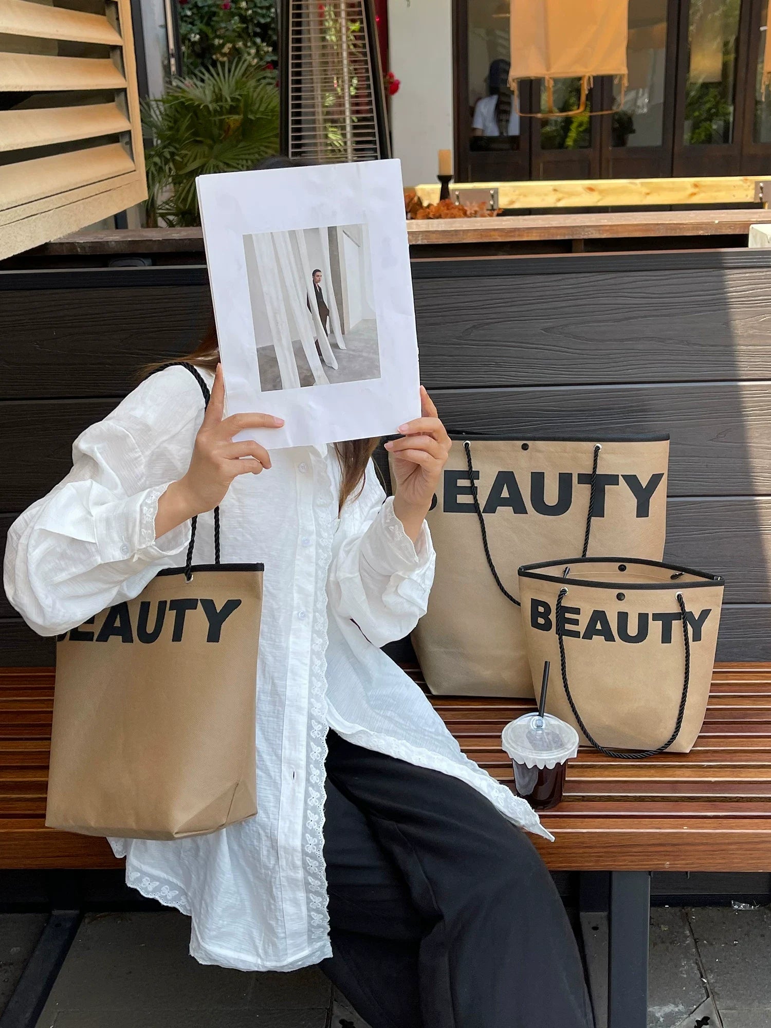 Woman holding a brown trapezoid non-woven tote bag