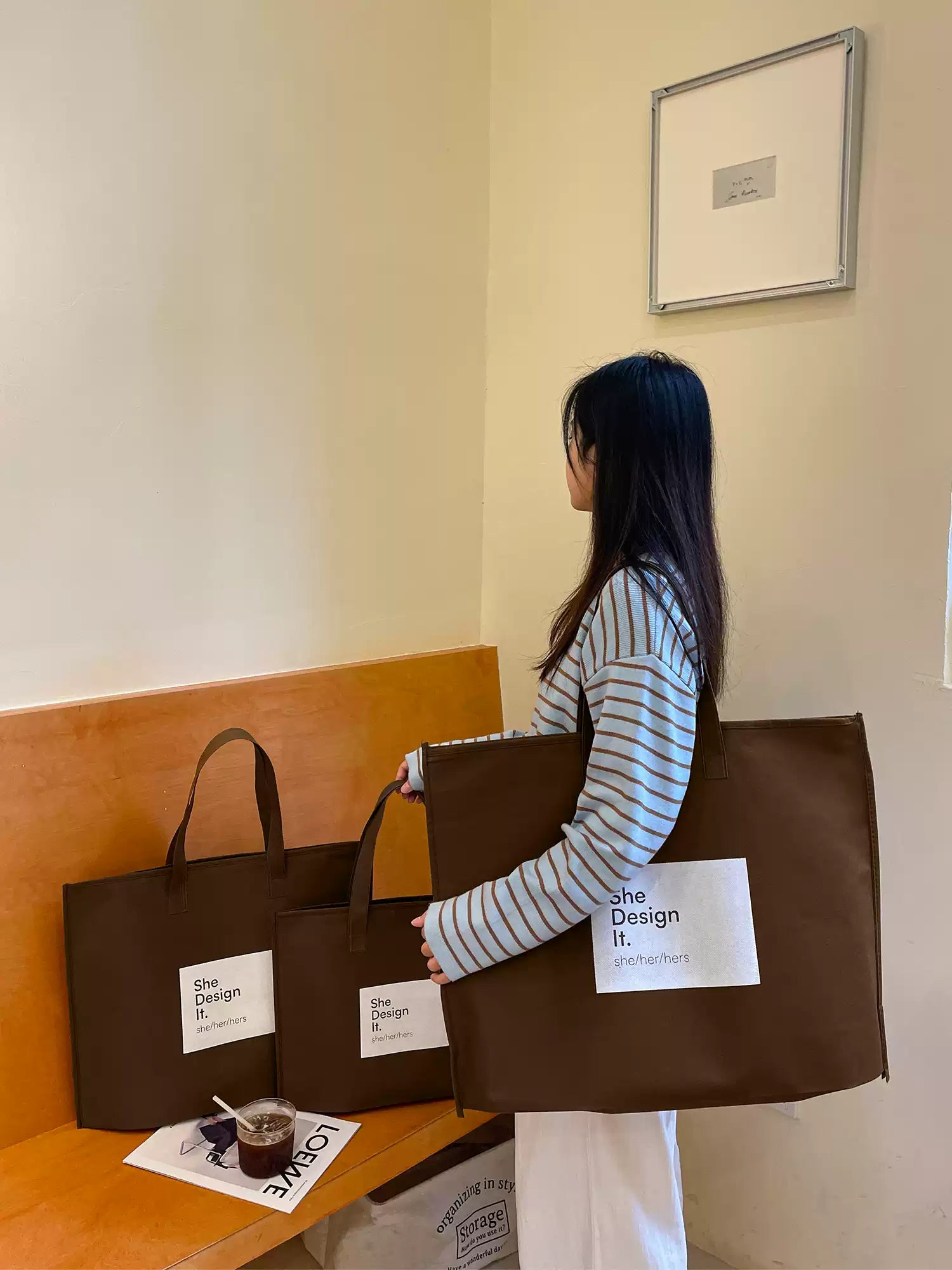 Woman carrying an oversized brown zippered non-woven tote bag