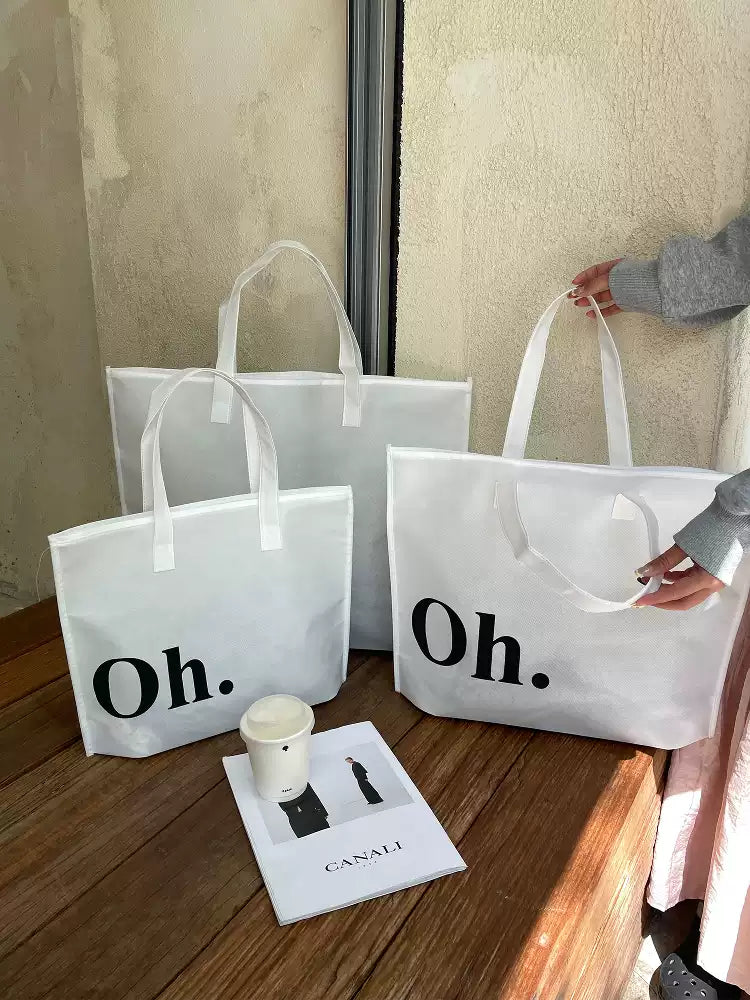 Woman carrying a white Oh zippered non-woven tote bag