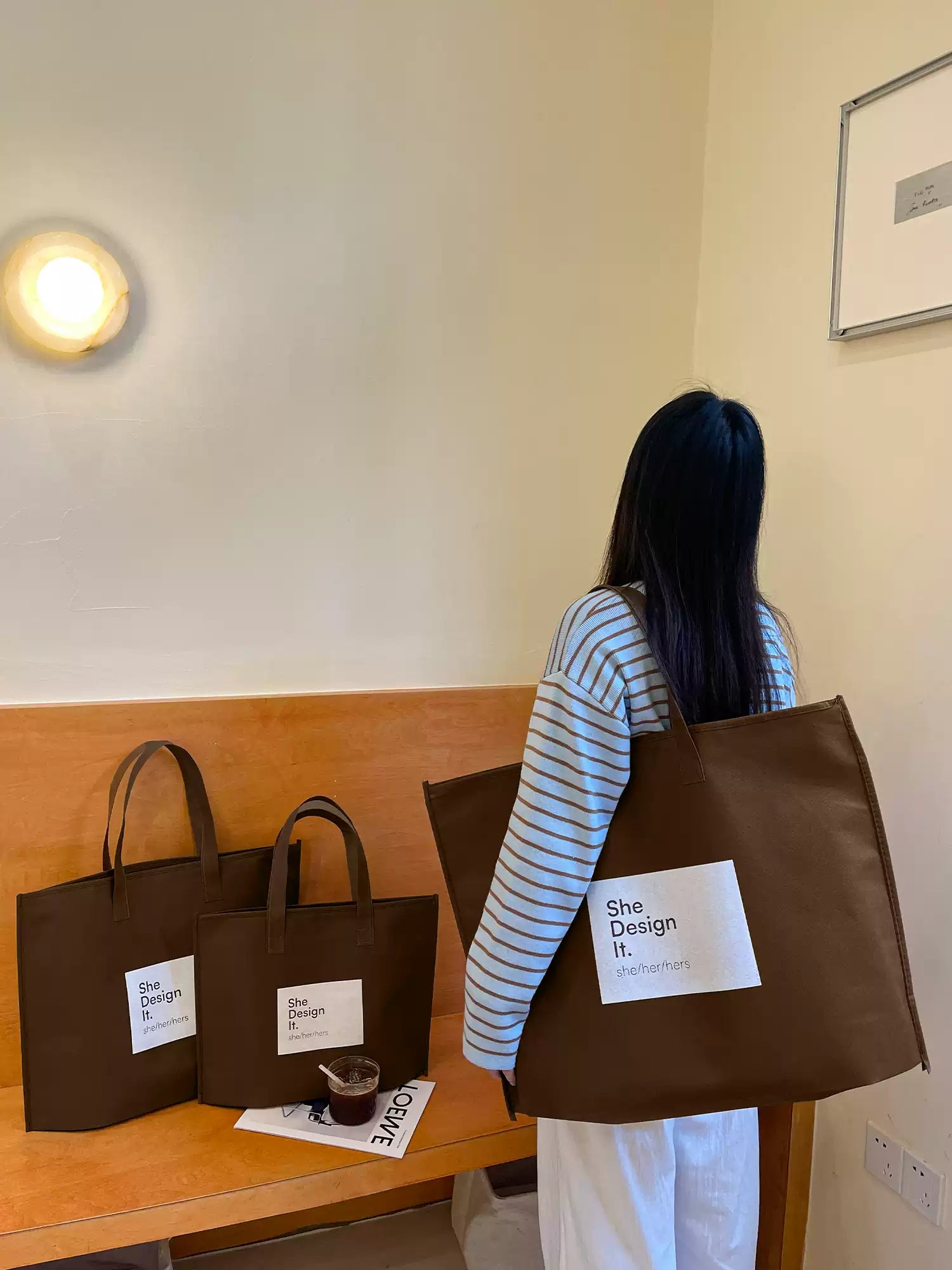 Brown zippered non-woven tote bags displayed in three sizes