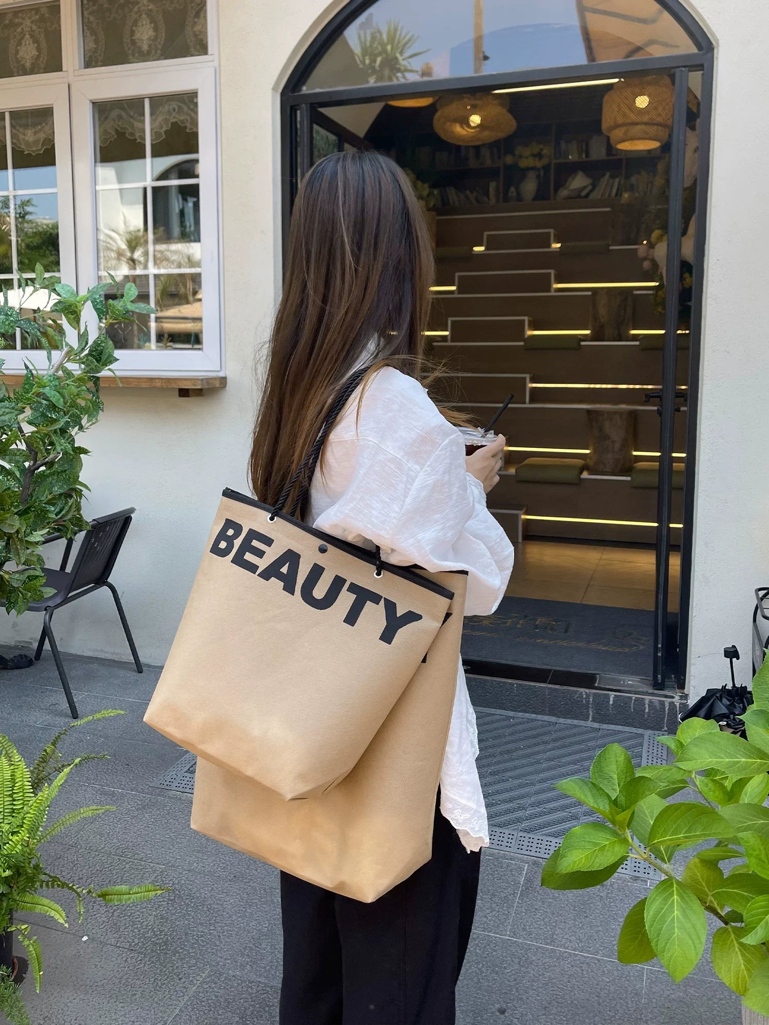 Woman carrying a large brown non-woven shopping bag