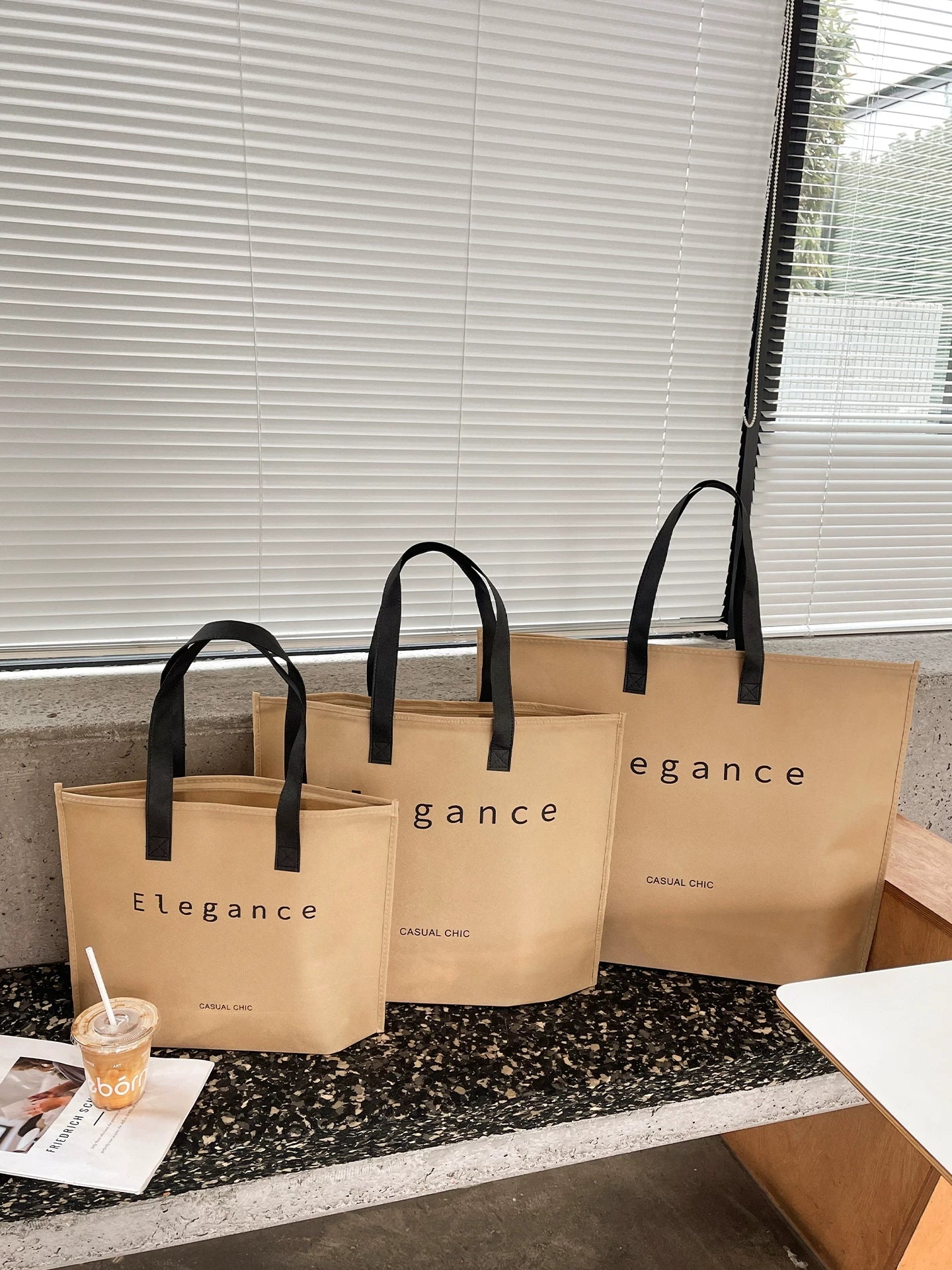 Tan zipper non-woven tote bags arranged for retail display