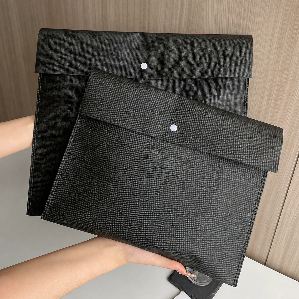 Black envelope-style non-woven bags with snap closures