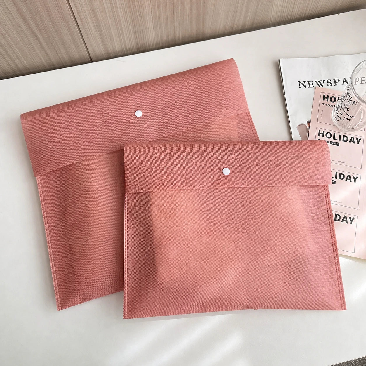 Pink envelope-style non-woven bags with snap closures