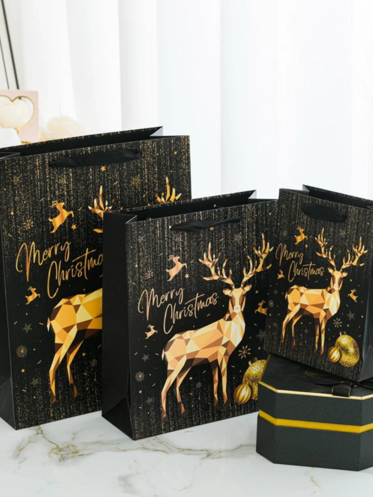 Black-and-gold Christmas paper gift bags with ribbon handles