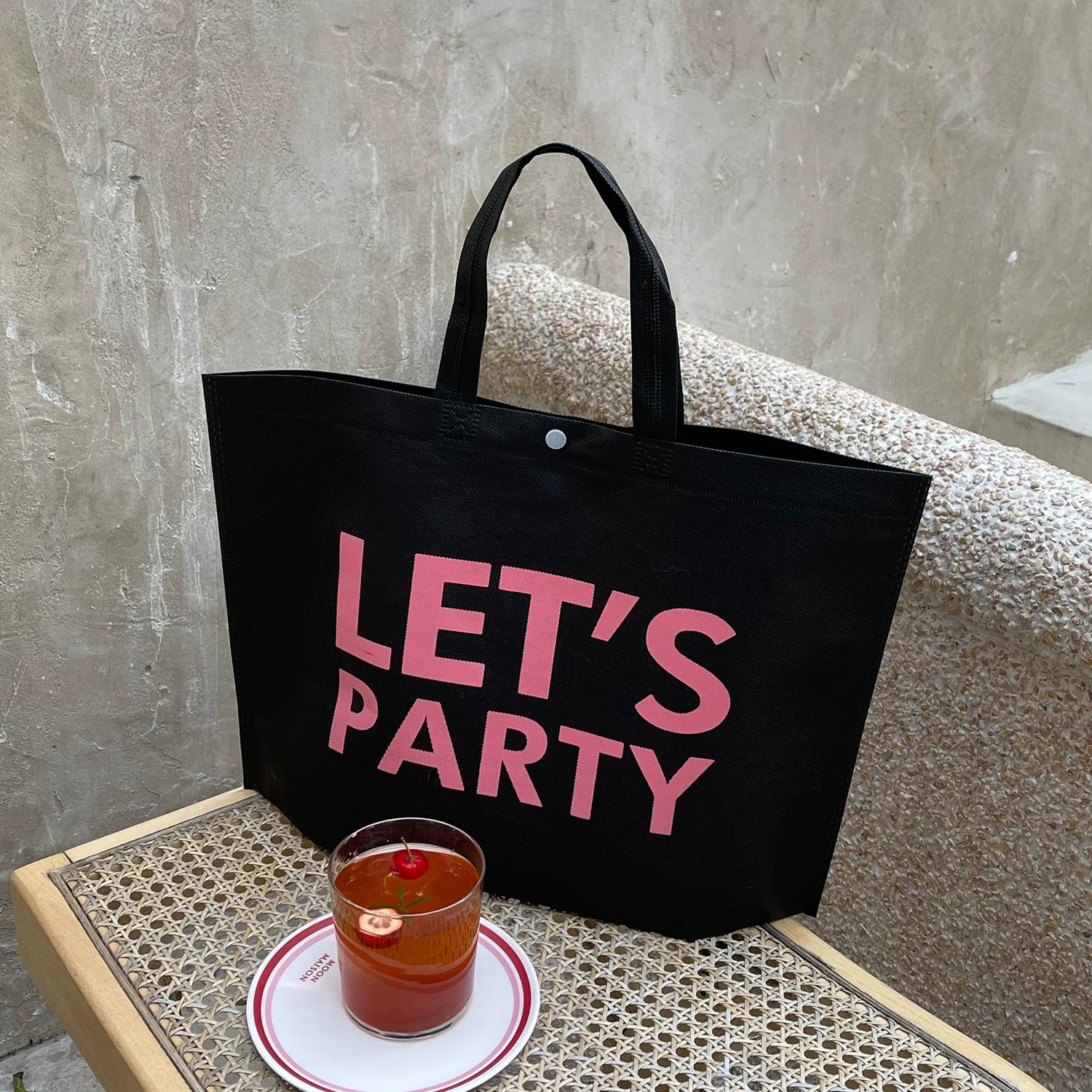Black non-woven tote bag with Let’s Party print