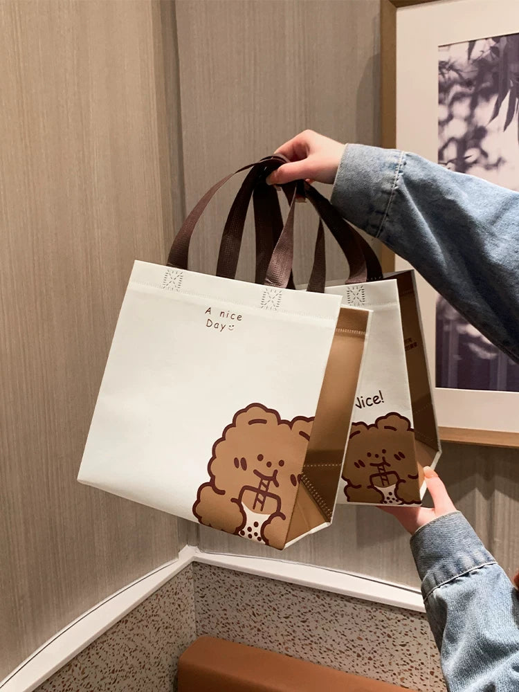 Bear design laminated non-woven gift bags shown in medium and extra-large sizes