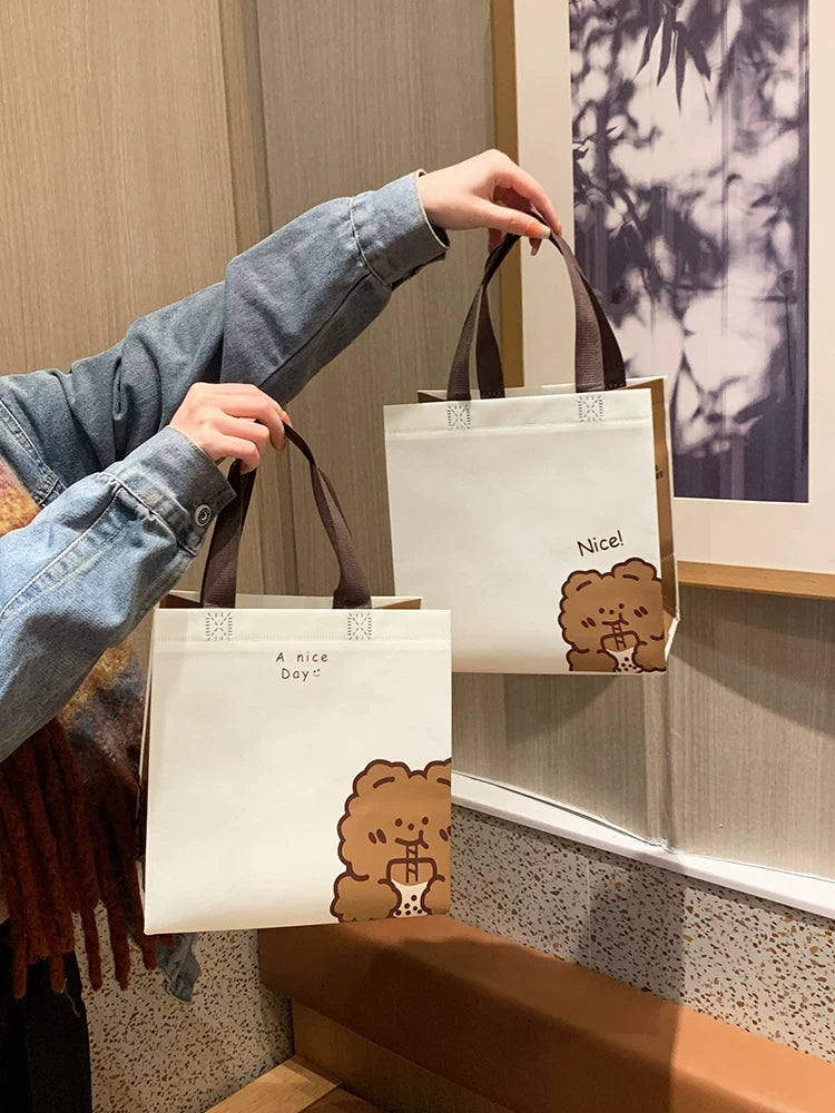 Medium and extra-large bear design non-woven gift bags carried side by side