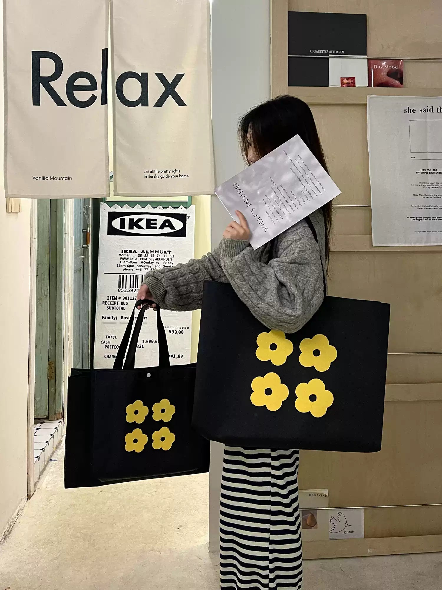 Large yellow flower non-woven tote bag carried in a retail lifestyle setting