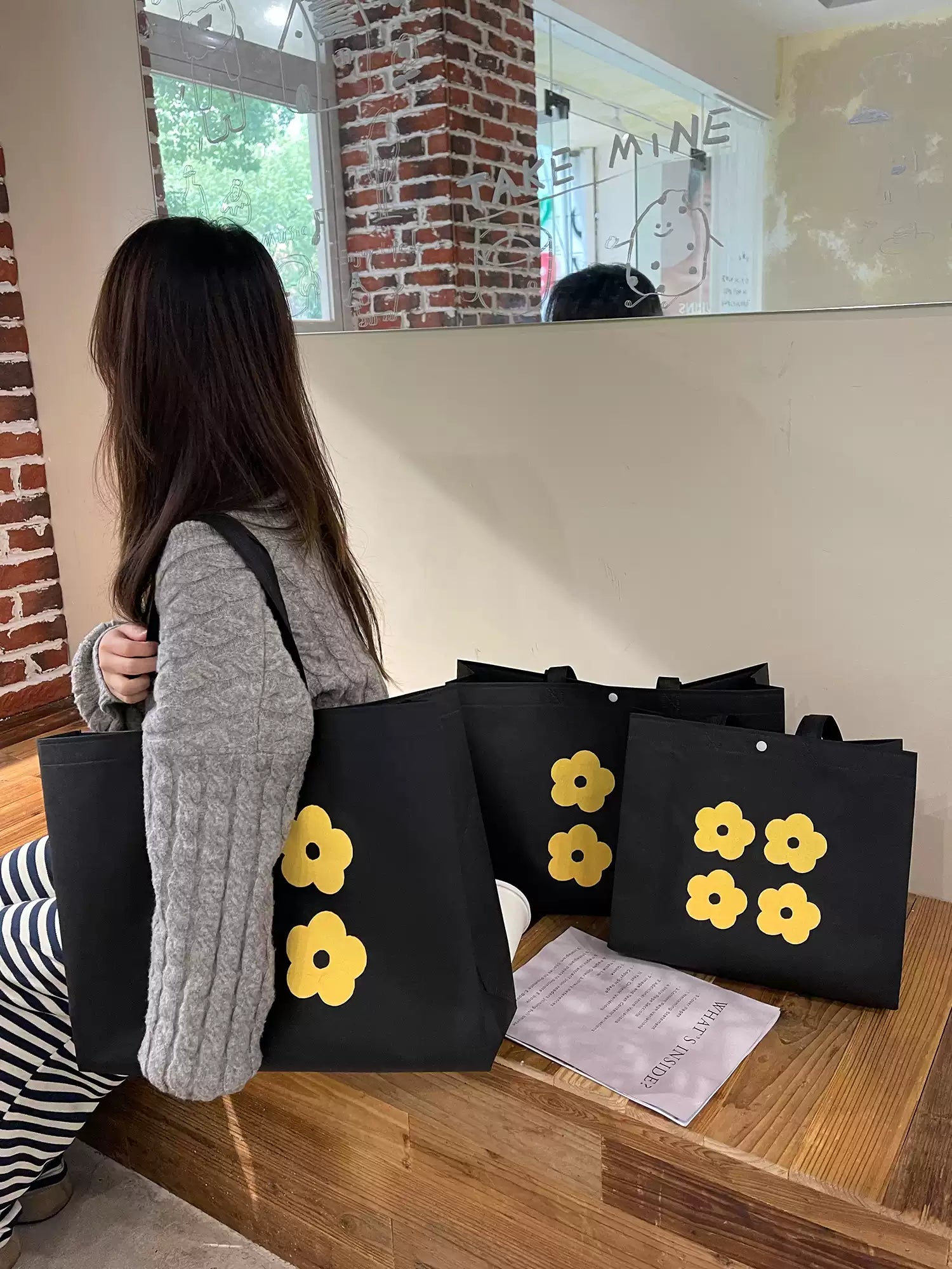Yellow flower non-woven tote bags arranged for apparel retail packaging