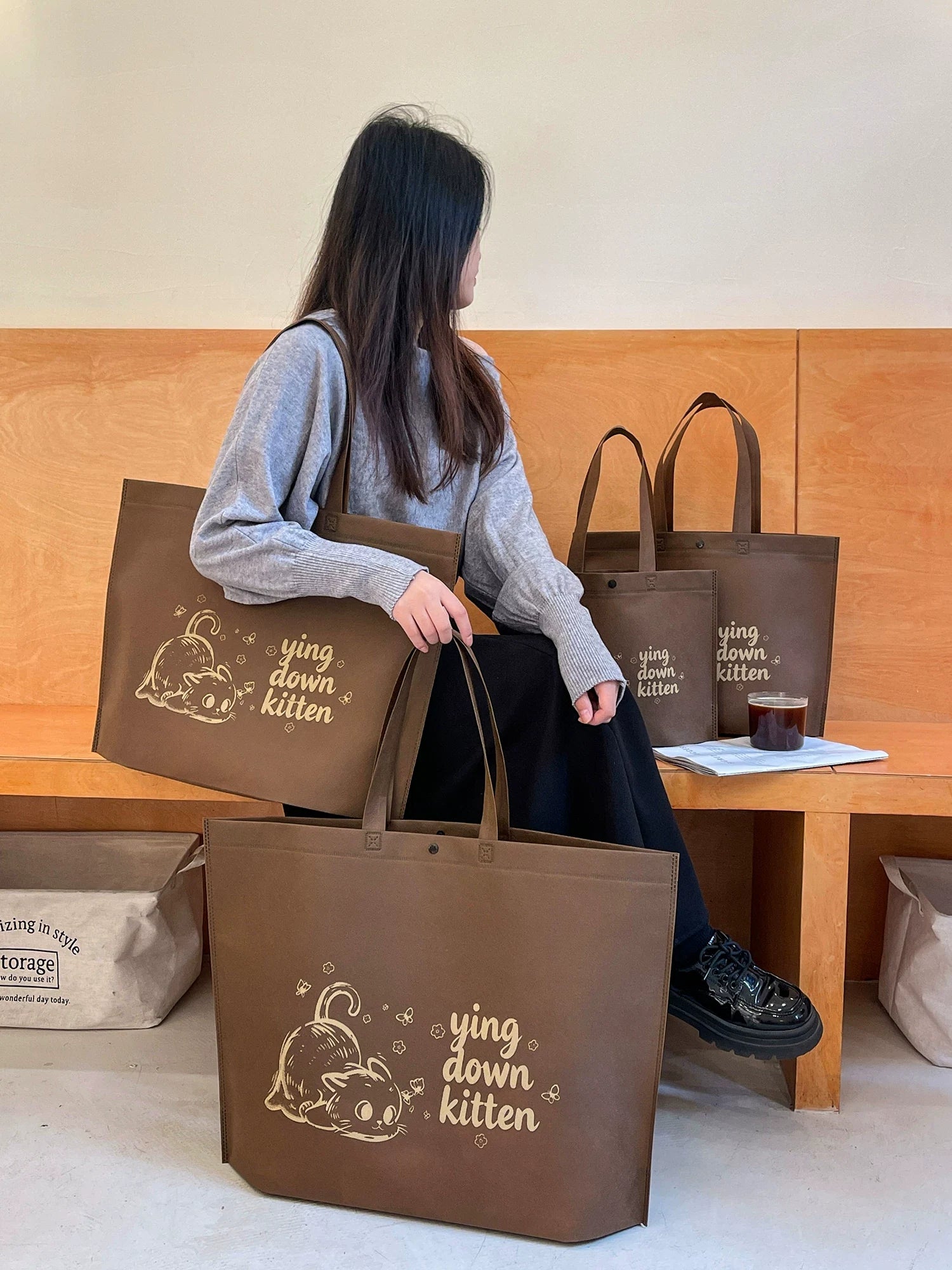 Brown cat snap-closure non-woven tote bag carried as boutique packaging