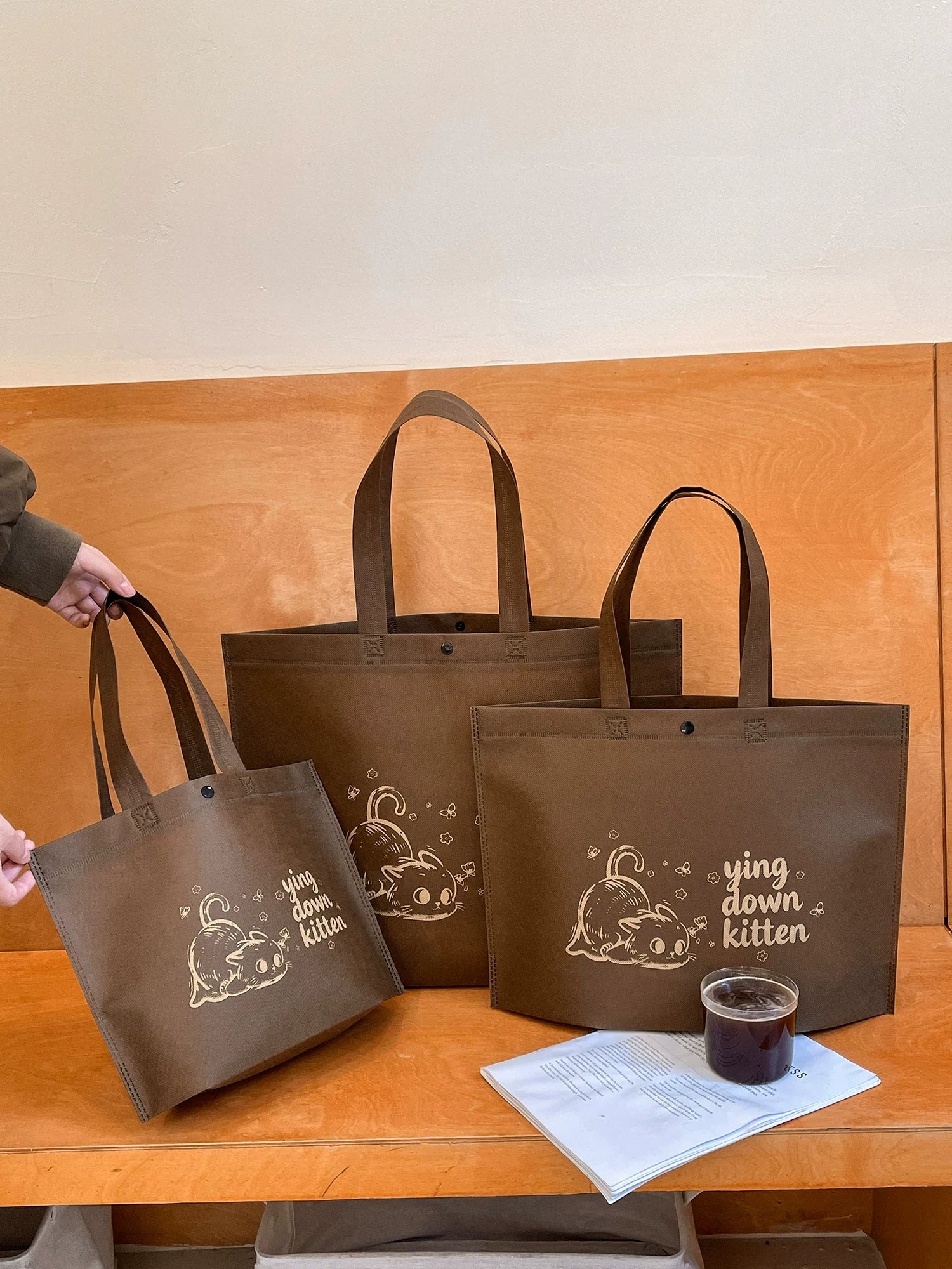 Custom non-woven tote bags shown in four available sizes