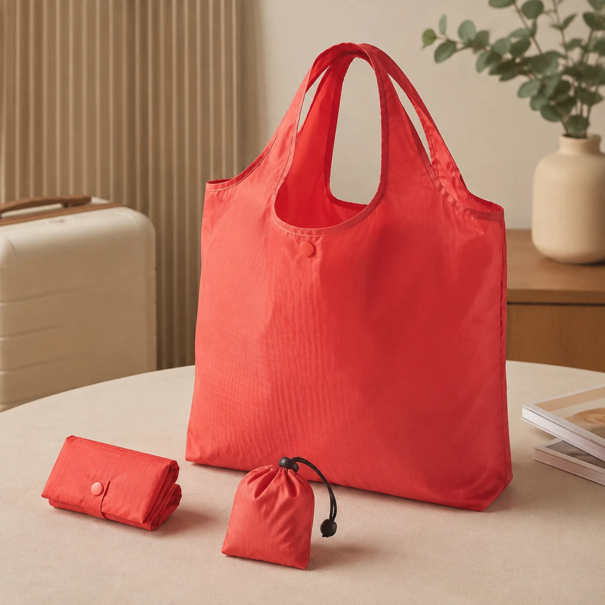 Coral foldable reusable shopping bag shown open, folded and packed into its pouch