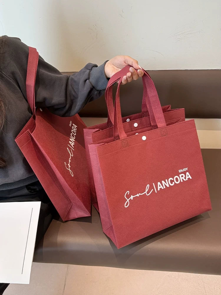 Red non-woven tote bag carried by hand