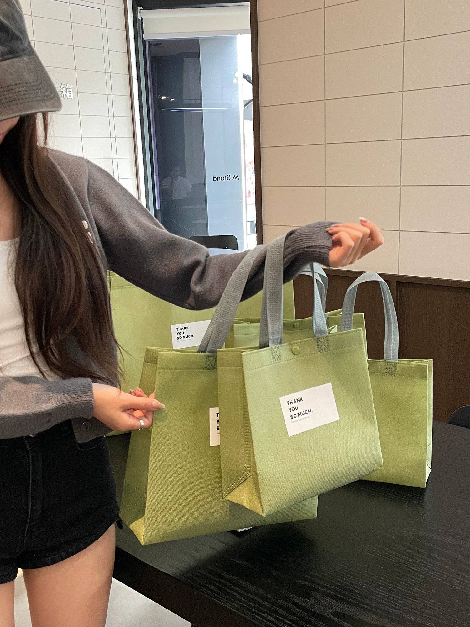 Custom snap-button non-woven tote bags in multiple sizes for retail packaging