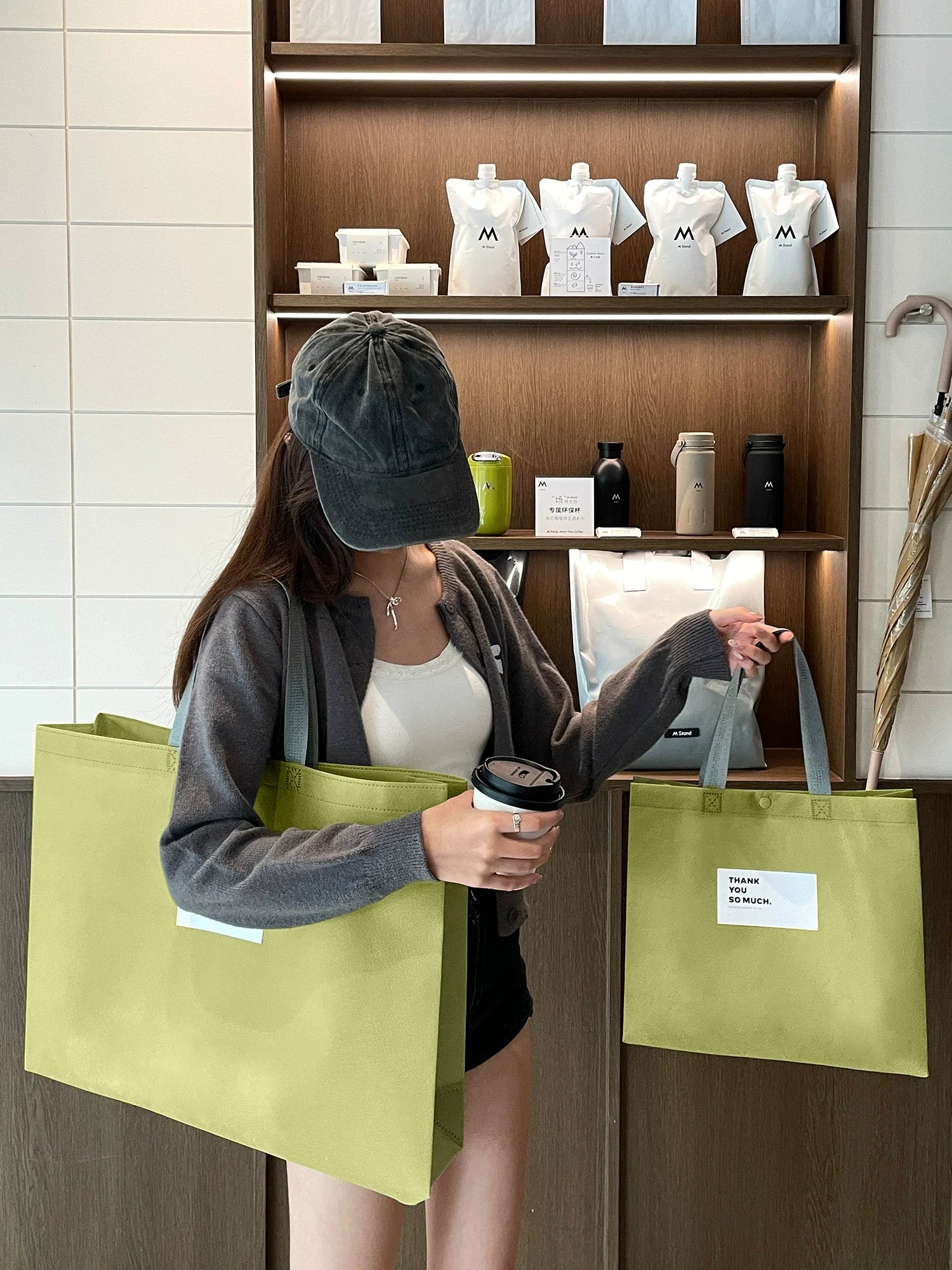 Reusable non-woven tote bags carried in a boutique retail setting