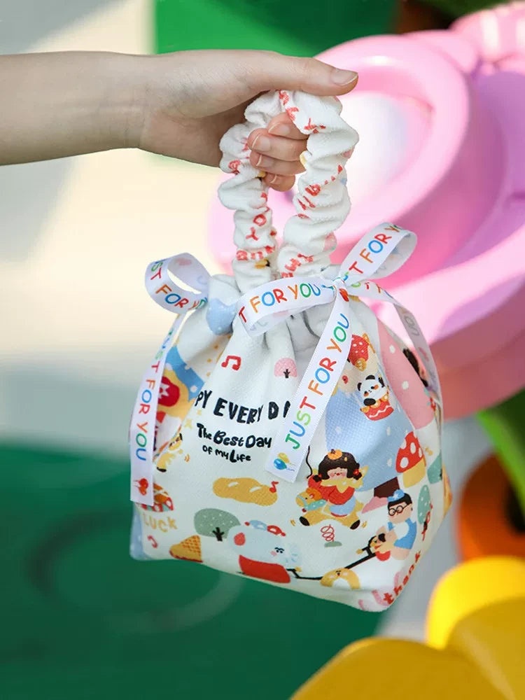 Hand-held fabric drawstring gift bag with decorative handle