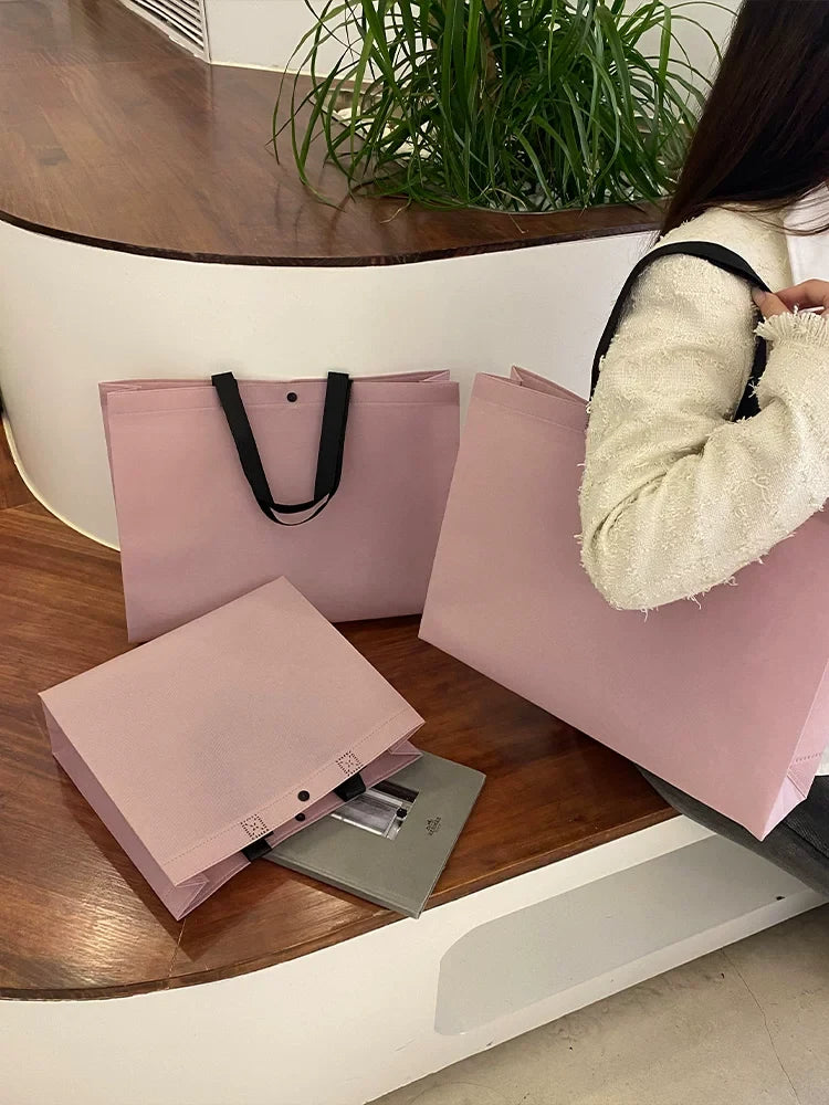 Foldable purple non-woven tote bags with reinforced handles