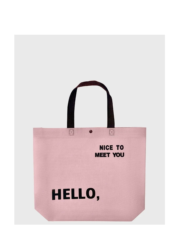 Front view of a blush pink non-woven tote bag with snap closure