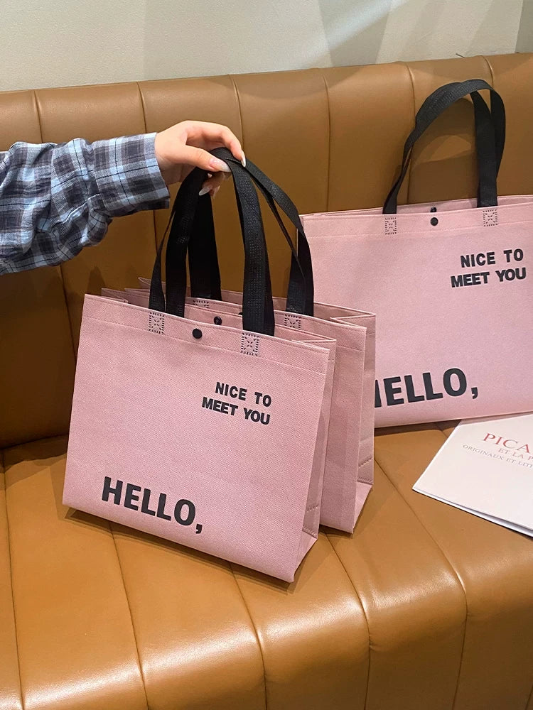 Blush pink non-woven tote bags shown in multiple sizes