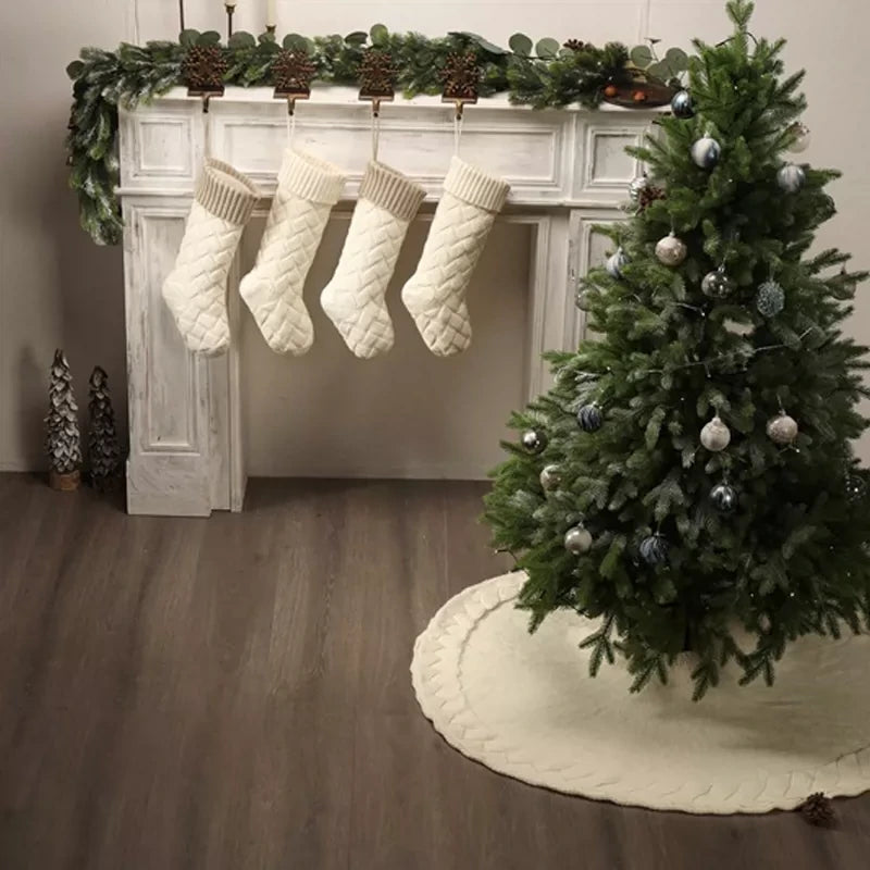 Ivory knitted Christmas stocking gift bags on a mantel
