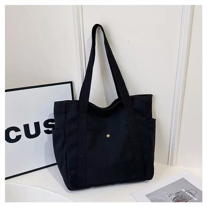 Black open-top canvas tote bag with dual side pockets