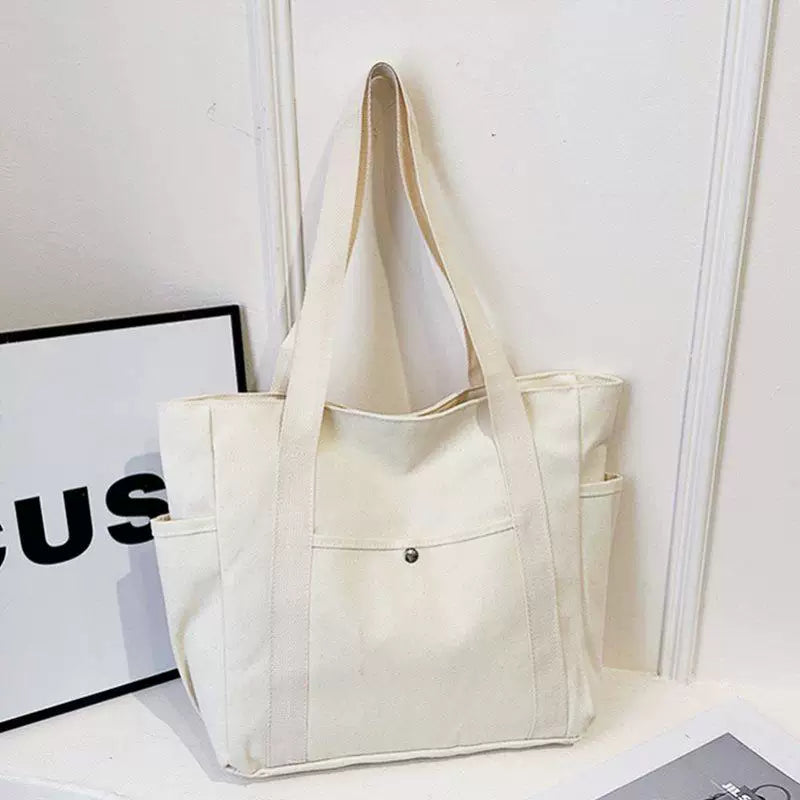 Off-white open-top canvas tote bag with dual side pockets
