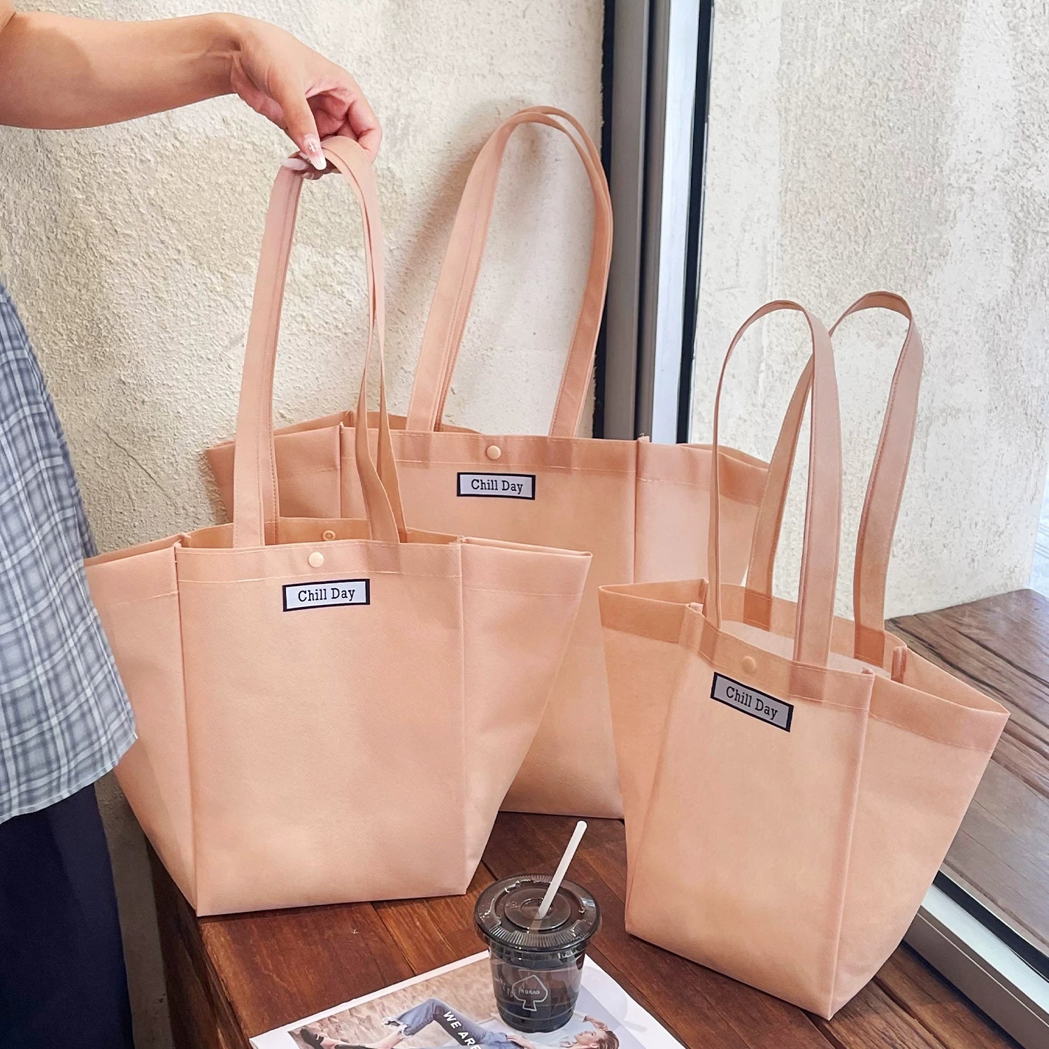 Light pink trapezoid non-woven tote bag with woven label