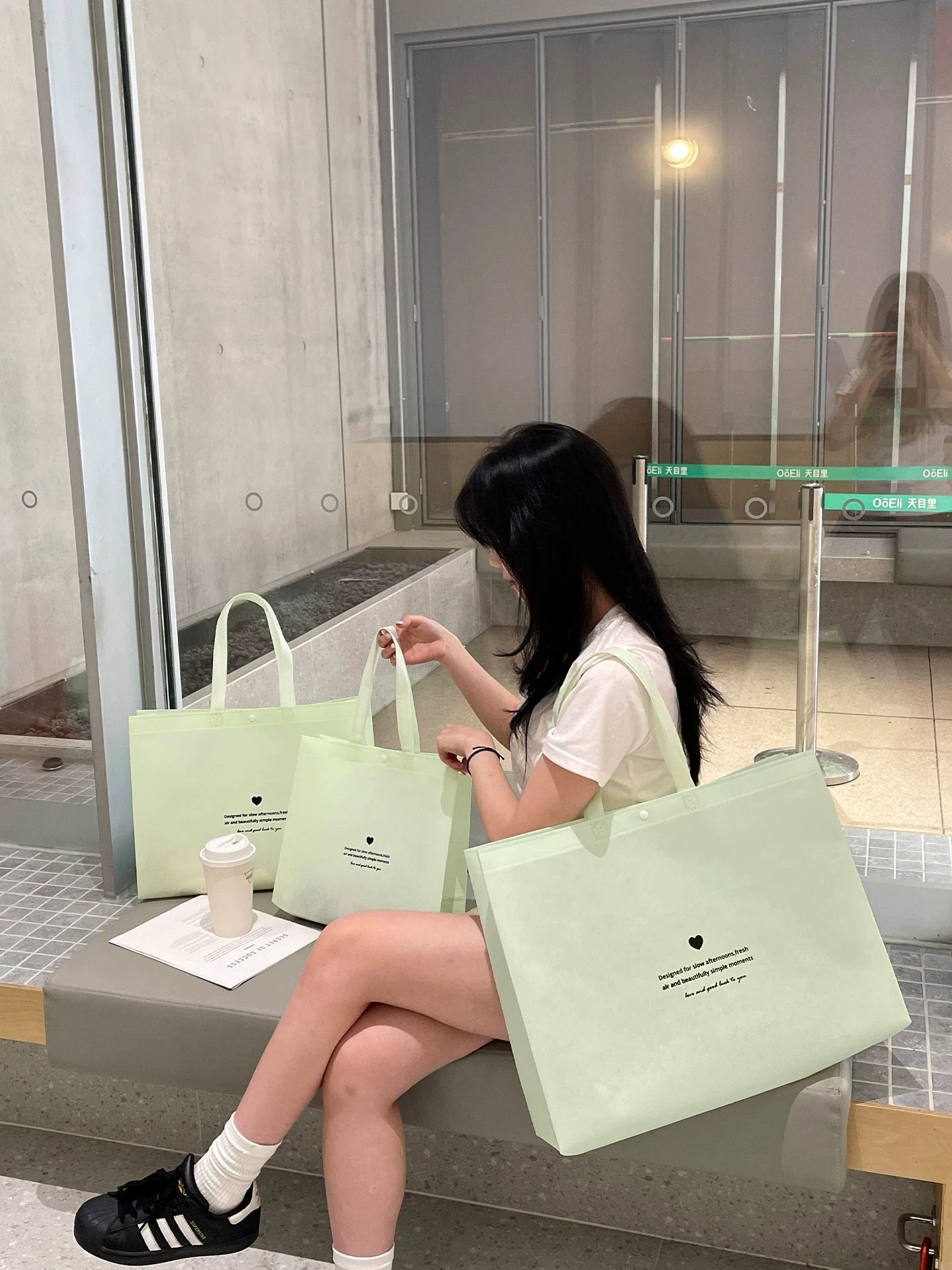 Mint green non-woven tote bags in a boutique lifestyle setting