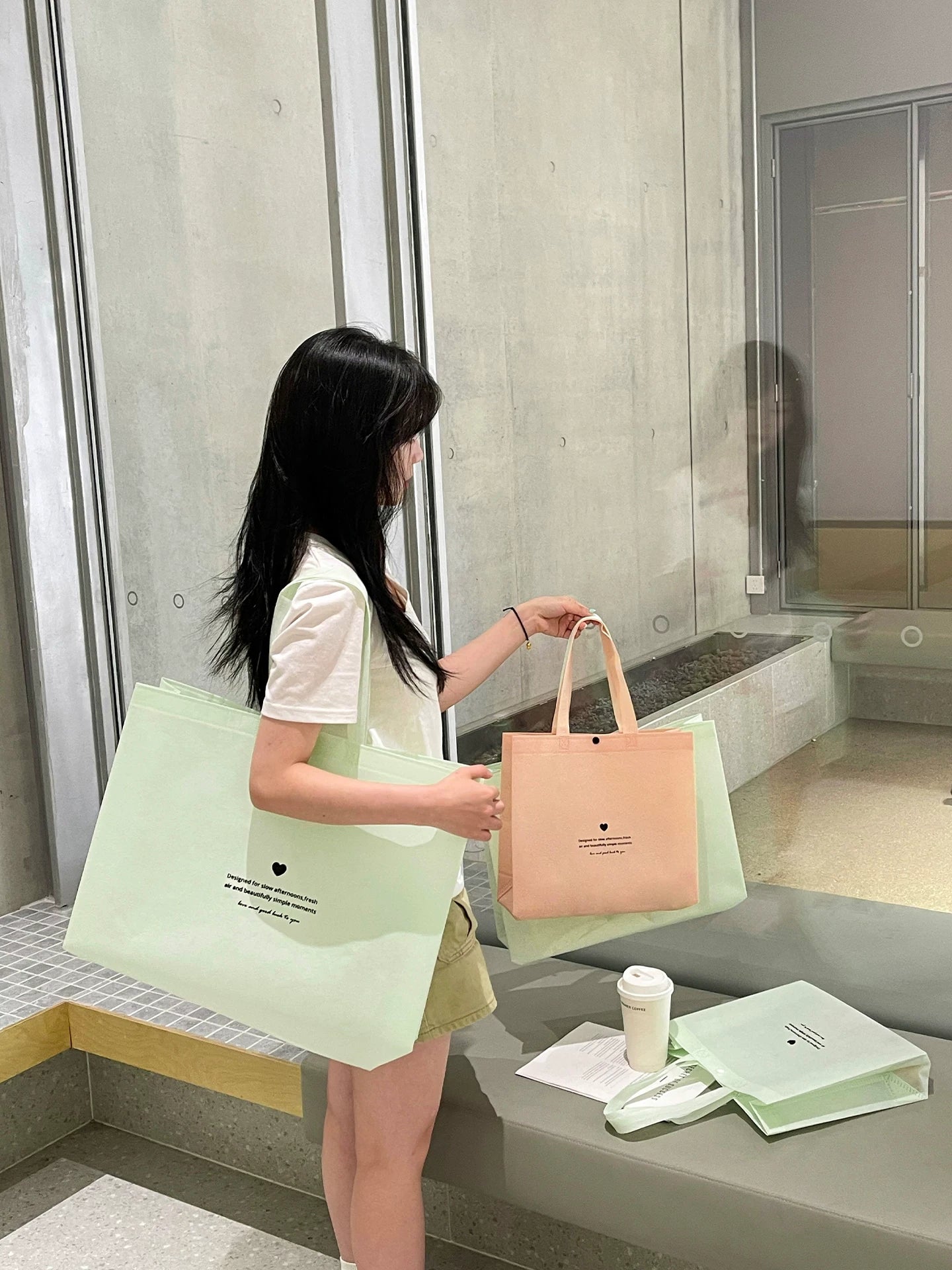 Mint green and peach non-woven tote bags in a lifestyle setting