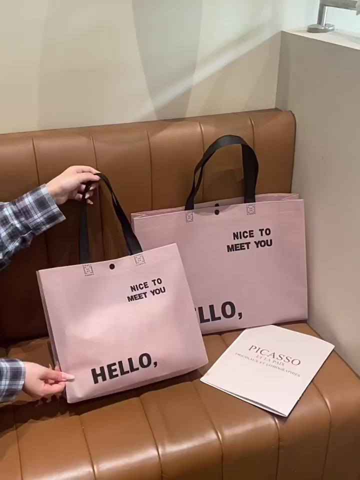 Blush pink non-woven tote bag product video showing size, handles and snap closure