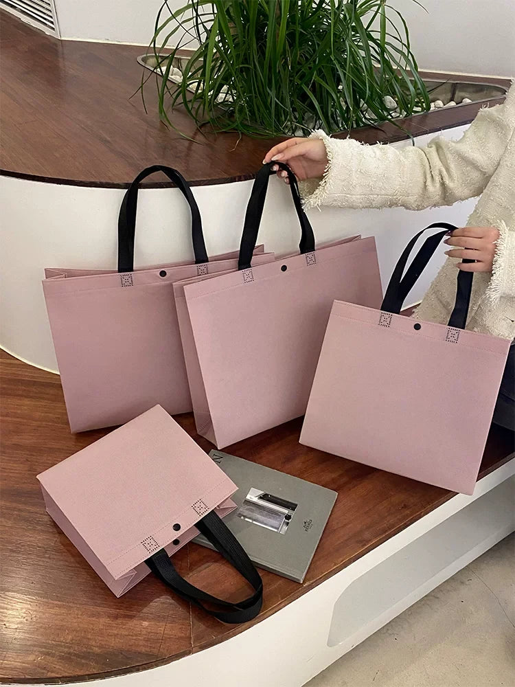 Purple non-woven tote bags shown in available sizes