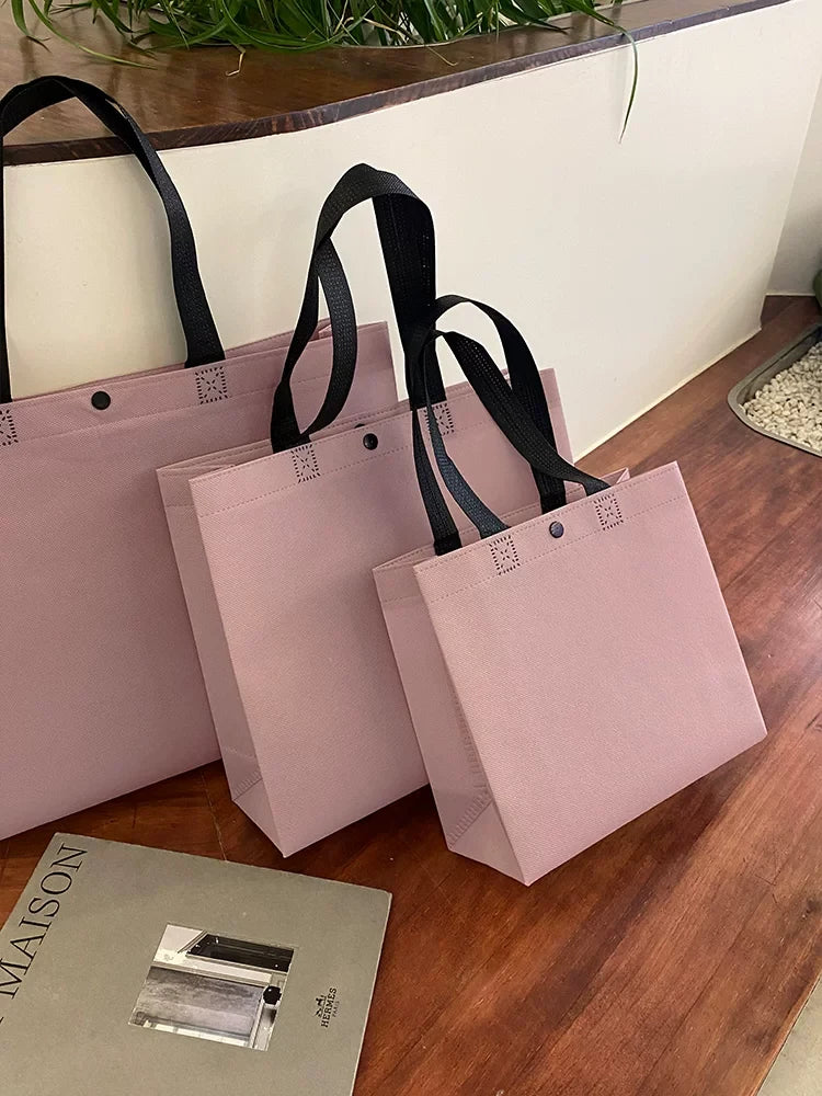 Purple shoulder-style non-woven tote bags in three sizes