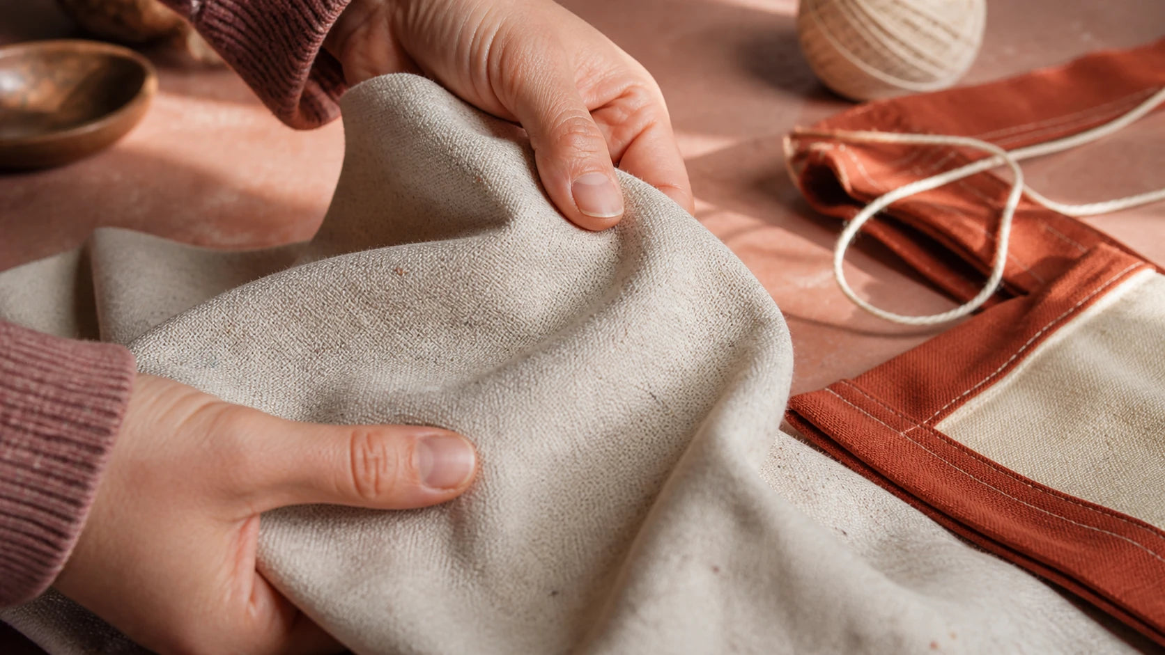 Hands feeling the soft breathable texture of speckled recycled cotton canvas