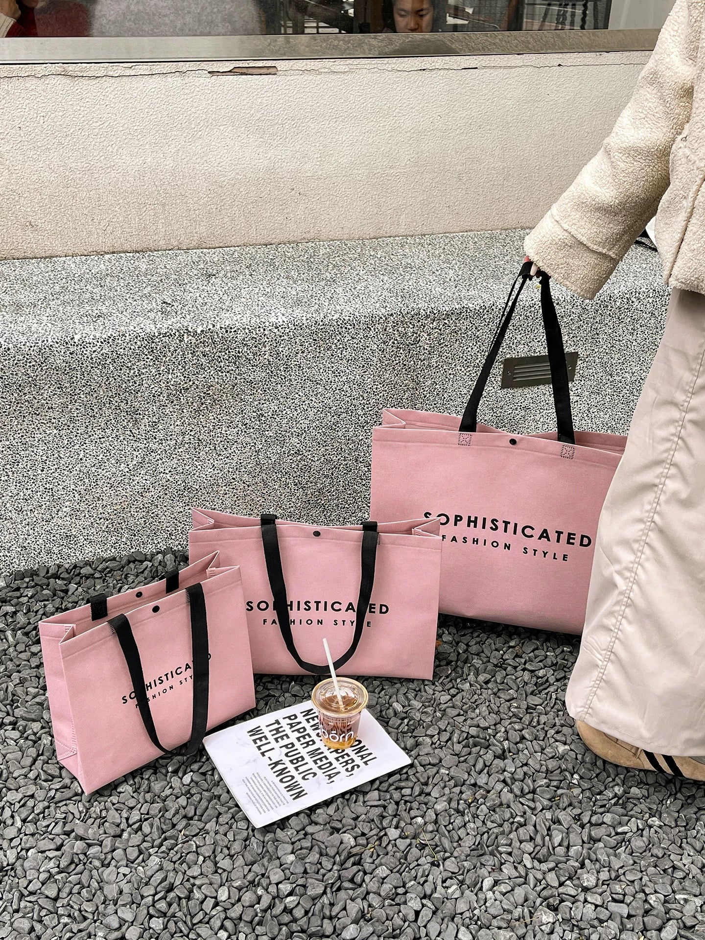Pink woven-handle non-woven tote bags in a lifestyle setting